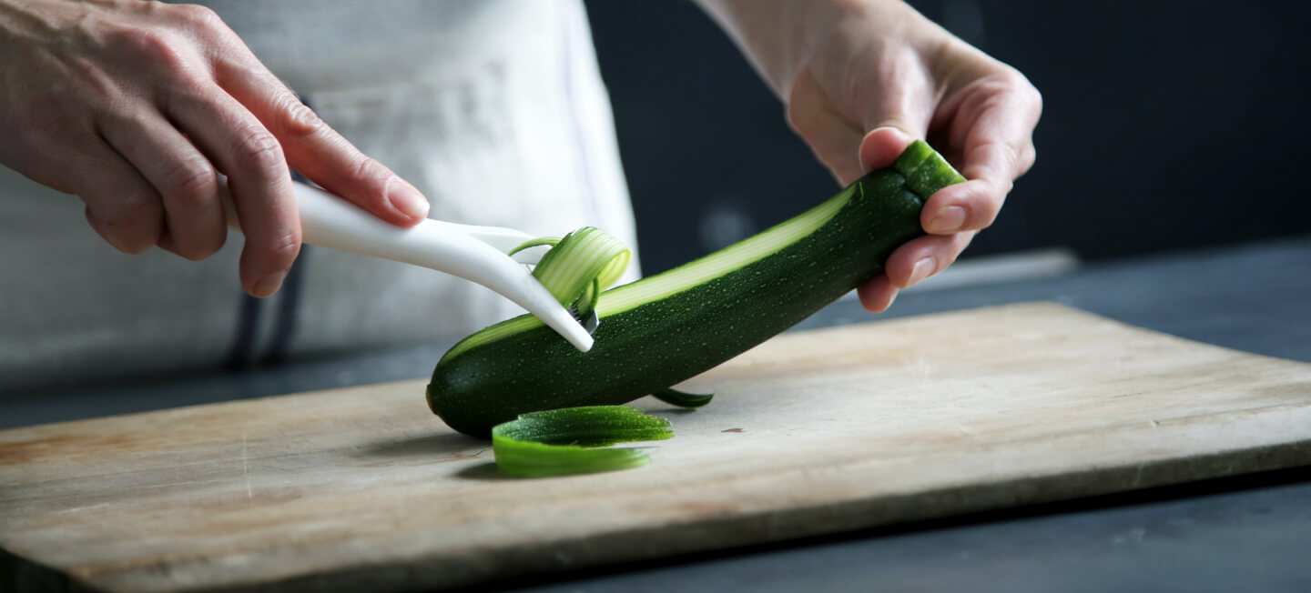 Pelando un calabacín sobre una tabla de madera